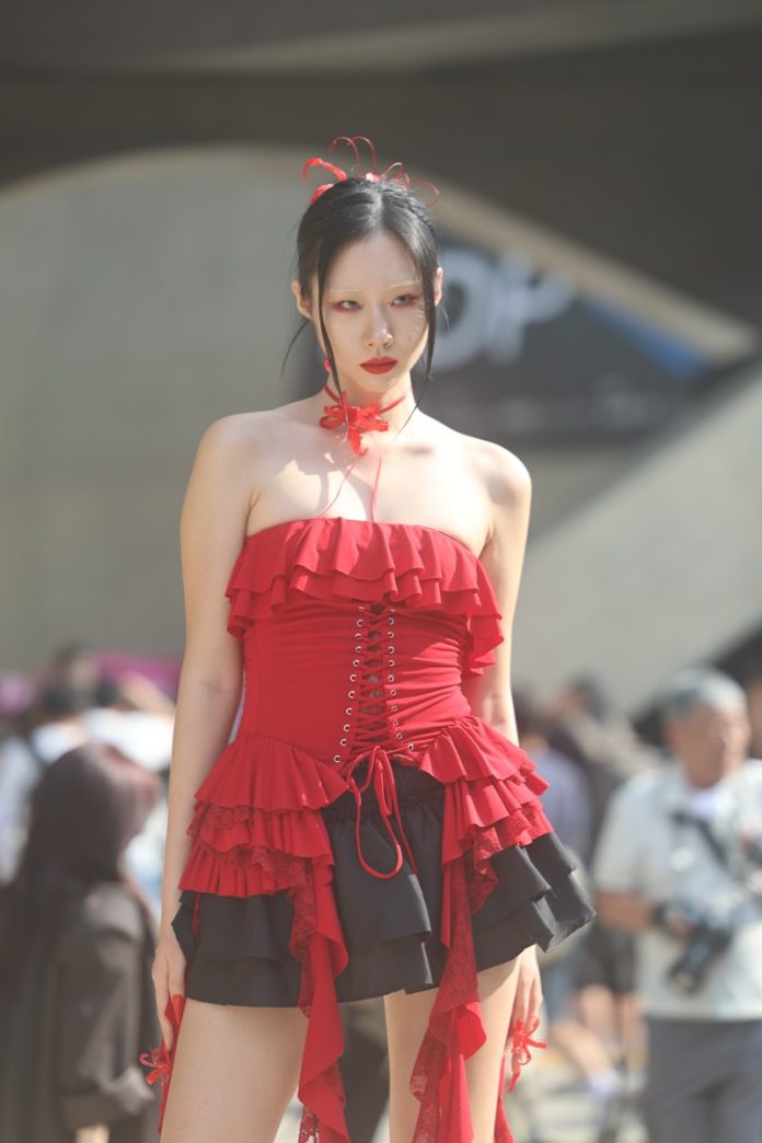 A woman in a red corset walking down a street