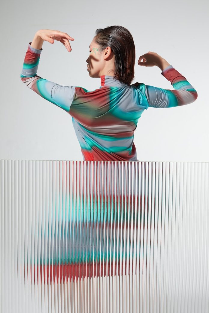 a woman standing in front of a white wall